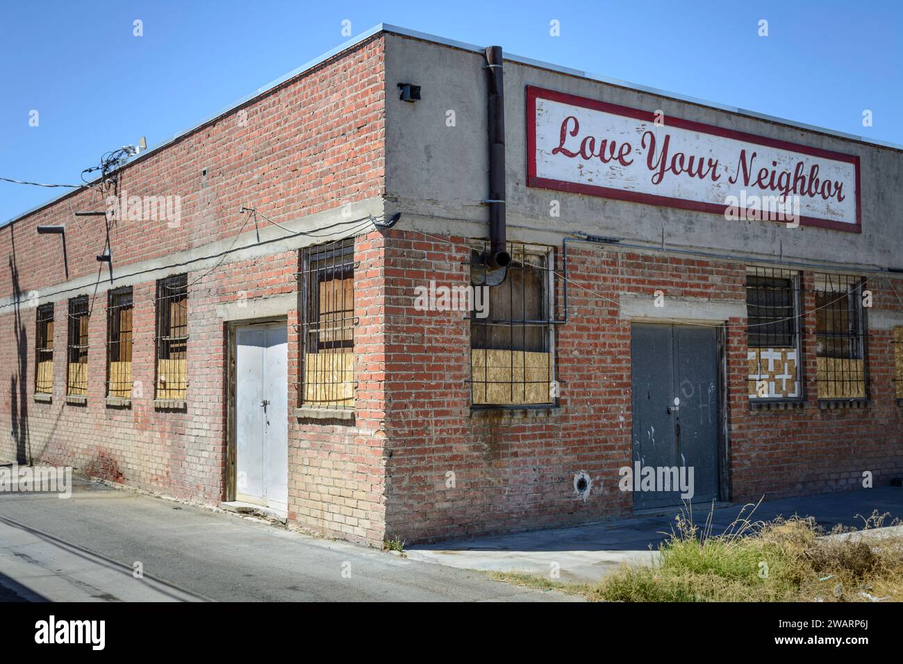 Un cartello su un vecchio magazzino a Mojave, California, dice: "Ama il tuo vicino". Foto Stock