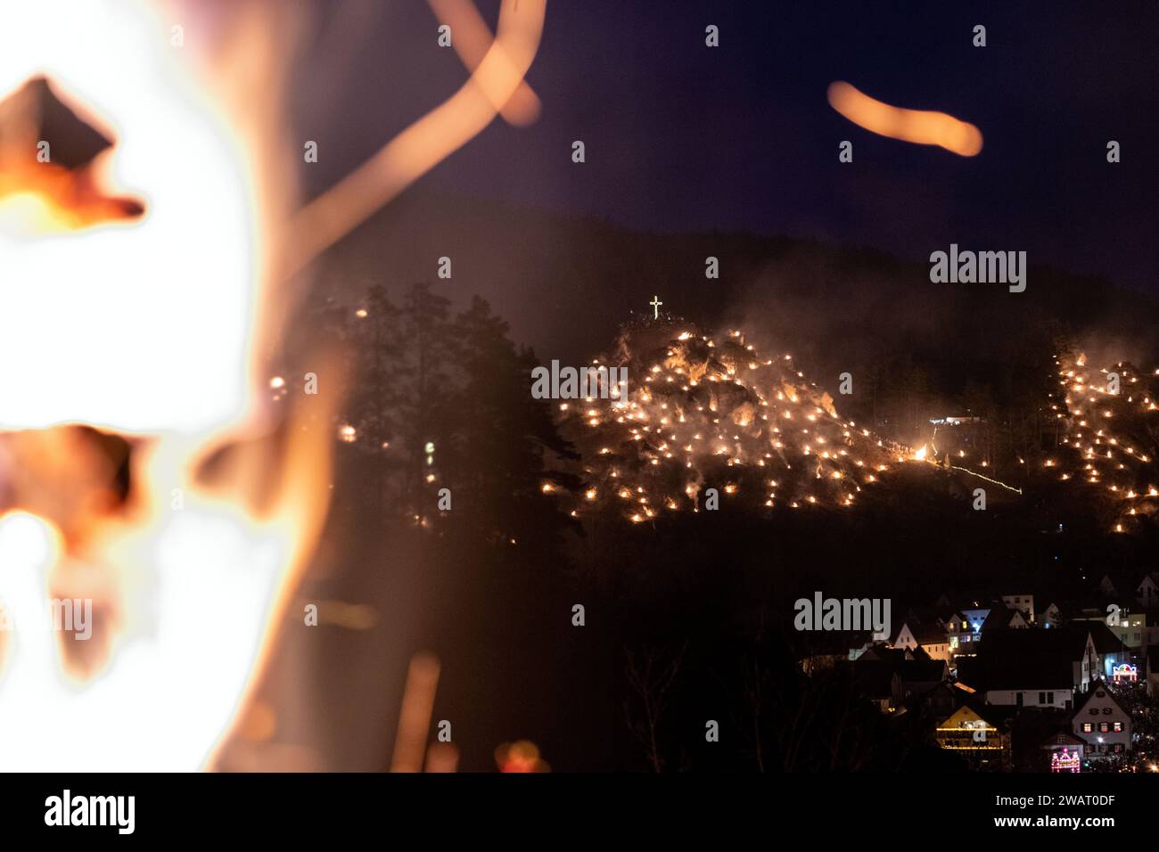 Pottenstein, Germania. 6 gennaio 2024. Numerosi falò di montagna bruciano sui pendii rocciosi intorno alla città sull'Epifania. L'occasione è la festa cattolica dell'Adorazione perpetua. Migliaia di spettatori vengono ogni anno nella piccola città della Svizzera franconica sull'Epifania. (A dpa 'gli incendi illuminano le pendici rocciose di Pottenstein') crediti: Pia Bayer/dpa/Alamy Live News Foto Stock