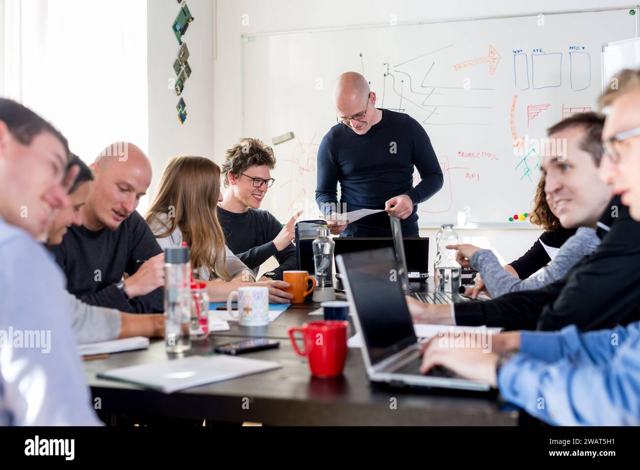 Soluzione dei problemi relativi alle startup e all'imprenditorialità. I giovani programmatori di intelligenza artificiale e gli sviluppatori di software IT collaborano con il brainstorming e la programmazione su computer desktop di una startup condividono lo spazio dell'ufficio Foto Stock