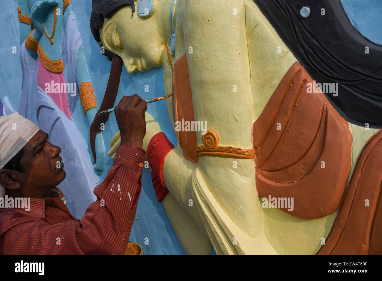 Un operaio dipinge una scultura d'arte prima della visita del primo ministro indiano Narendra modi nei pressi di un cantiere ad Ayodhya. Ramnagari Ayodhya, un tempo nota per le sue strade strette e le strade in decomposizione, sta facendo progressi costanti: Tutte le strade e gli edifici che portano a RAM Janmabhoomi sono stati ampliati e ristrutturati per facilitare i viaggi. Foto Stock
