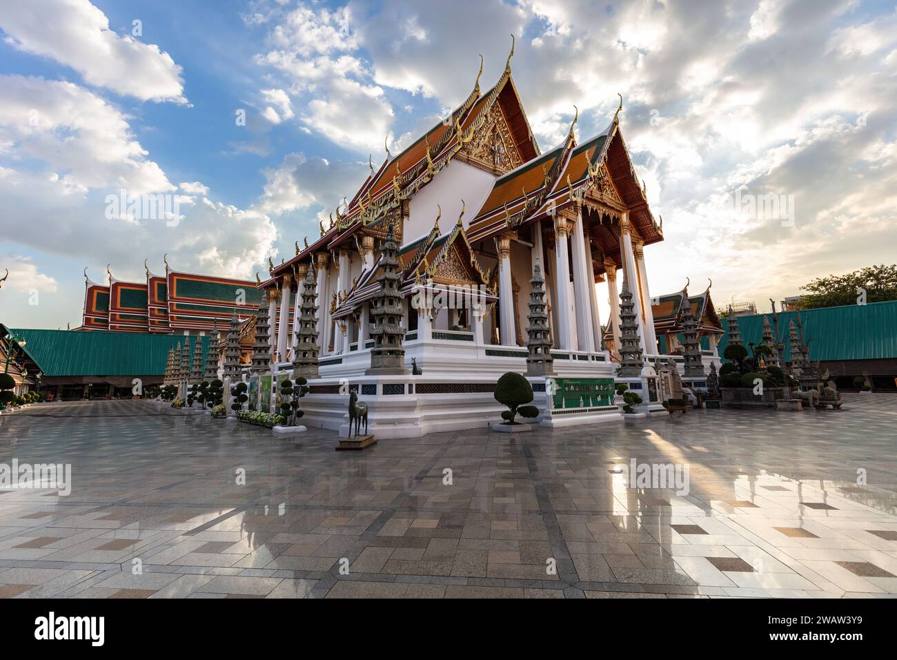 Wat Suthat a Bangkok, Thailandia. Tempio reale costruito nel 1807. Pavimento in marmo lucido in primo piano; cielo blu, nuvole soleggiate in alto. Foto Stock