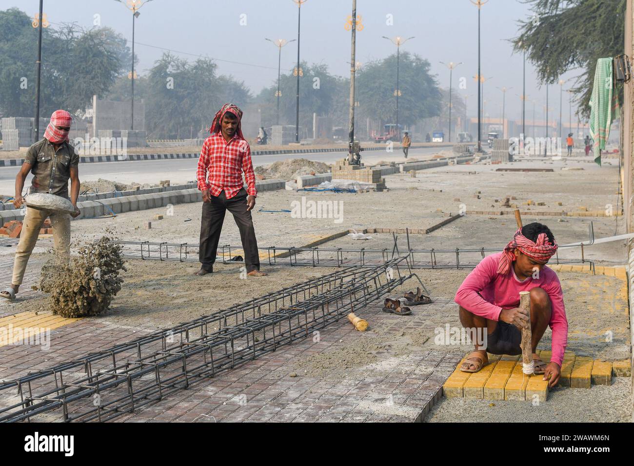 Ayodhya, India. 26 dicembre 2023. I lavoratori sono visti lavorare in un marciapiede di nuova costruzione, prima dell'inaugurazione del tempio RAM. Il tempio RAM sarà inaugurato il 22 gennaio dal primo ministro Narendra modi insieme al primo ministro dell'Uttar Pradesh, Yogi Adityanath. Quasi 8.000 dignitari, tra cui veggenti, industriali, VVIPS, attori e premiati Padam Bushan, sono stati invitati al grande evento. (Foto di Biplov Bhuyan/SOPA Images/Sipa USA) credito: SIPA USA/Alamy Live News Foto Stock