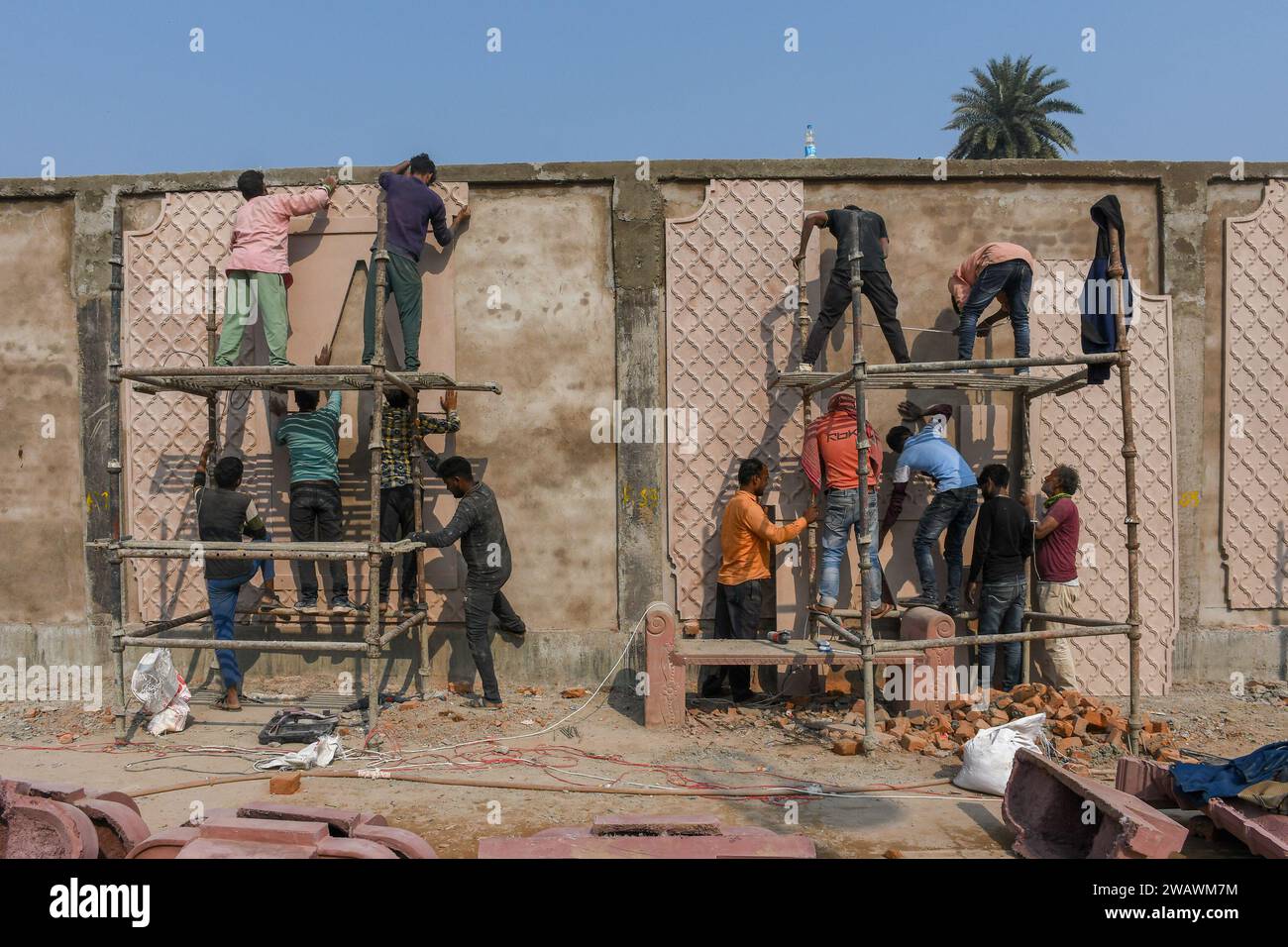 I lavoratori sono visti lavorare in un muro di nuova costruzione, prima dell'inaugurazione del tempio RAM. Il tempio RAM sarà inaugurato il 22 gennaio dal primo ministro Narendra modi insieme al primo ministro dell'Uttar Pradesh, Yogi Adityanath. Quasi 8.000 dignitari, tra cui veggenti, industriali, VVIPS, attori e premiati Padam Bushan, sono stati invitati al grande evento. Foto Stock