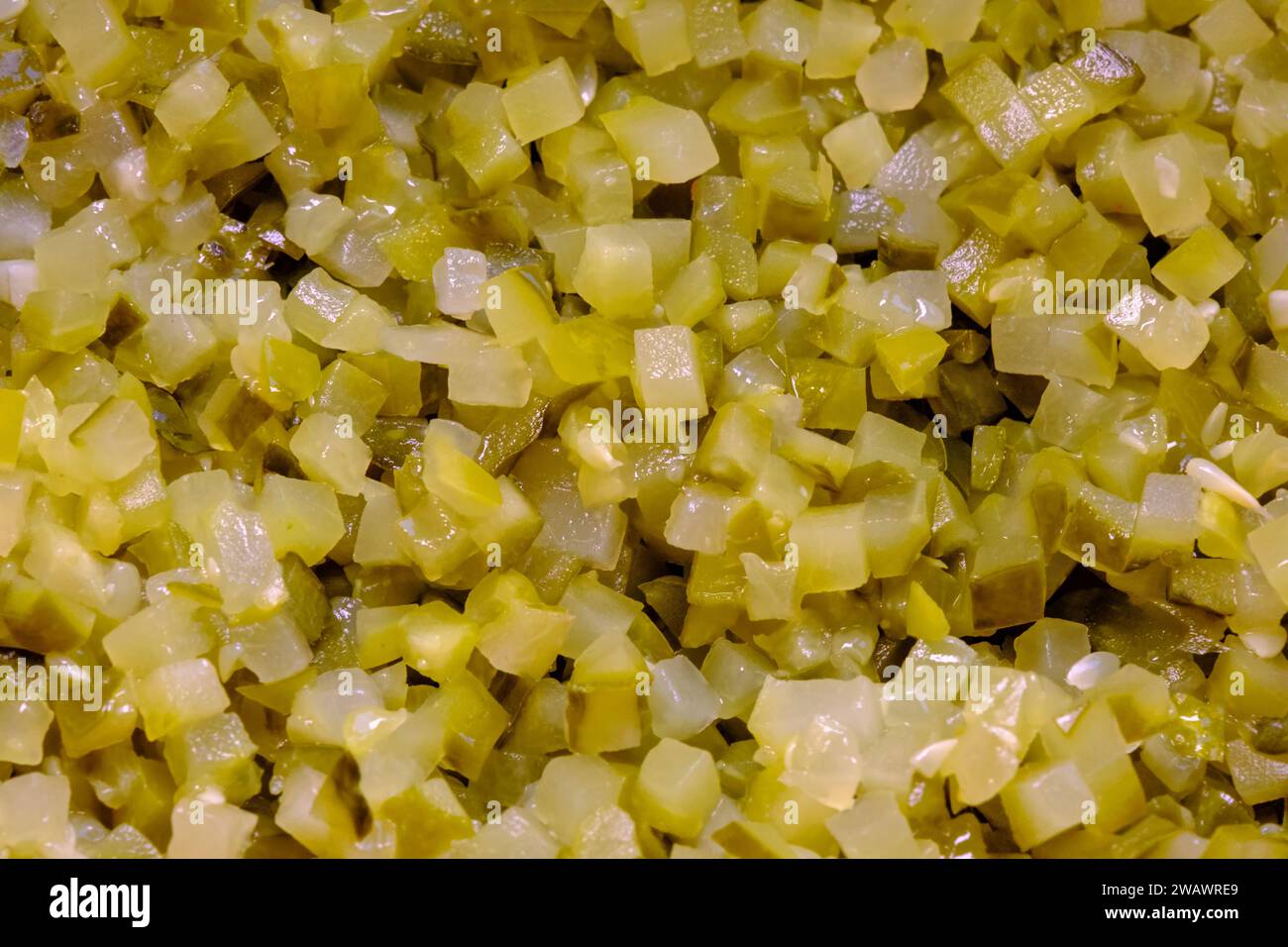 Tagliare una grande quantità di cetriolo sottaceto in piccoli cubetti. Foto Stock
