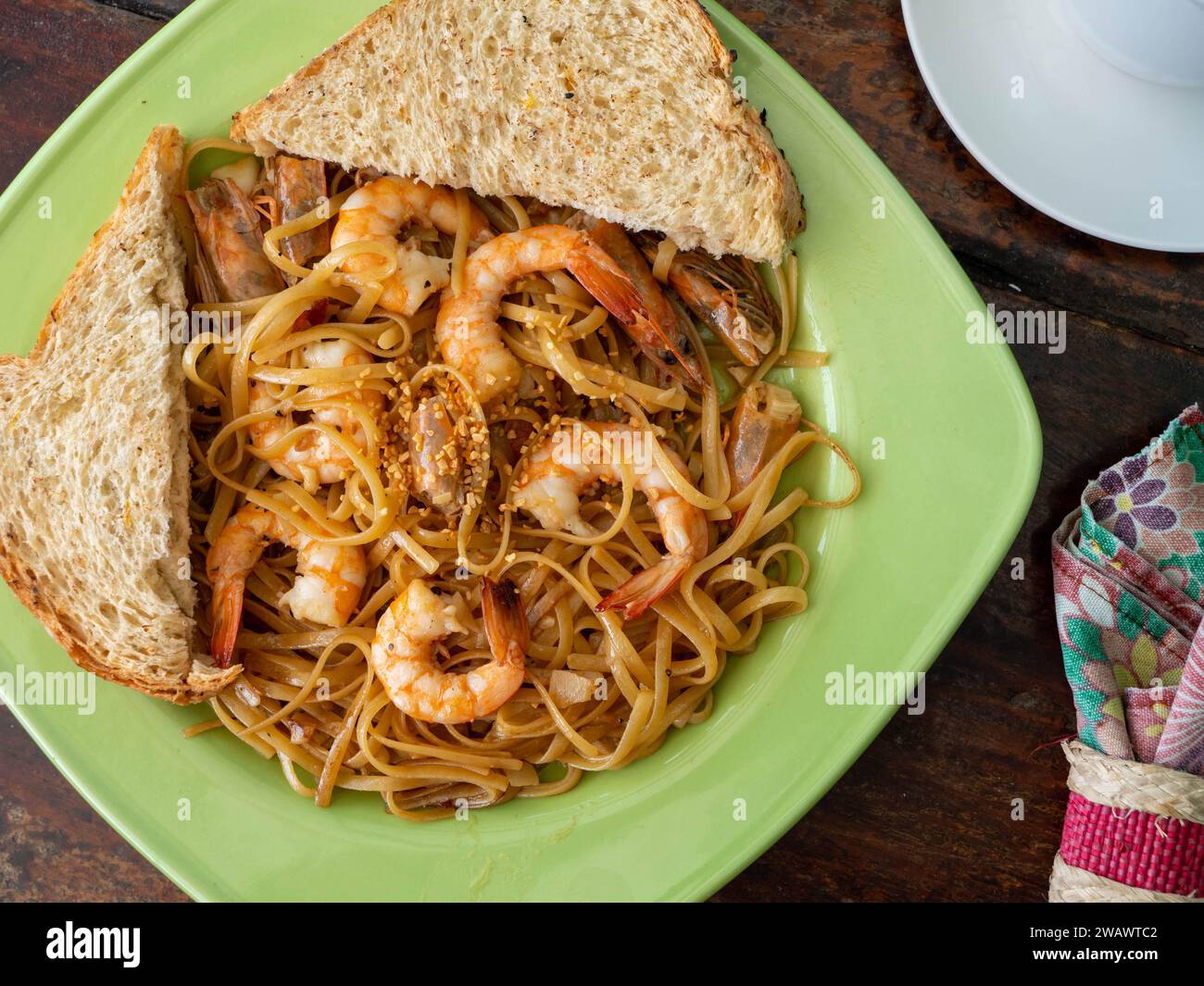 Spaghetti fatti in casa con gamberi e fette di pane integrale. Foto Stock