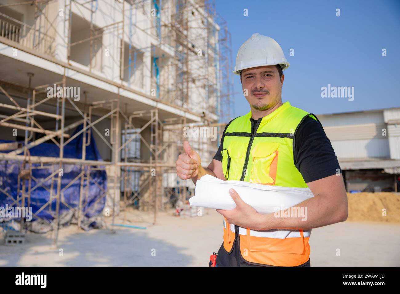 Ingegnere operaio edile professionista maschio. Costruttore di case immobiliari. Architetto intelligente che lavora in piedi in cantiere. Foto Stock