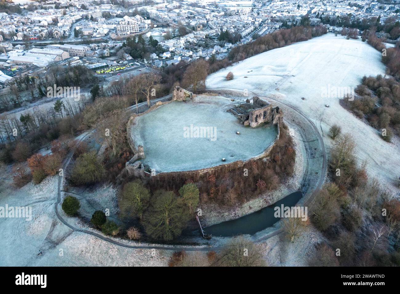 Kendal, Cumbria, 7 gennaio 2024 - Una notte di nebbia e temperature sotto lo zero ha portato una bella gelata mattutina alla città di Kendal in Cumbria domenica. Il castello di Kendal, che si affaccia sulla città medievale, era circondato da uno strato di ghiaccio bianco mentre gli escursionisti si godevano la vista. Le case ai piedi del castello sono sagomate in cerchi e gli ovali catturano anche il gelo. Credito: Stop Press Media/Alamy Live News Foto Stock