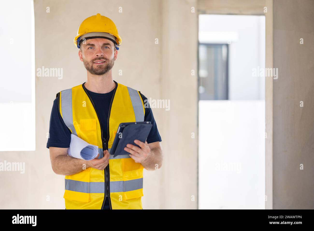 Ingegnere operaio edile professionista maschio. Costruttore di case immobiliari. Architetto intelligente che lavora in piedi in cantiere. Foto Stock