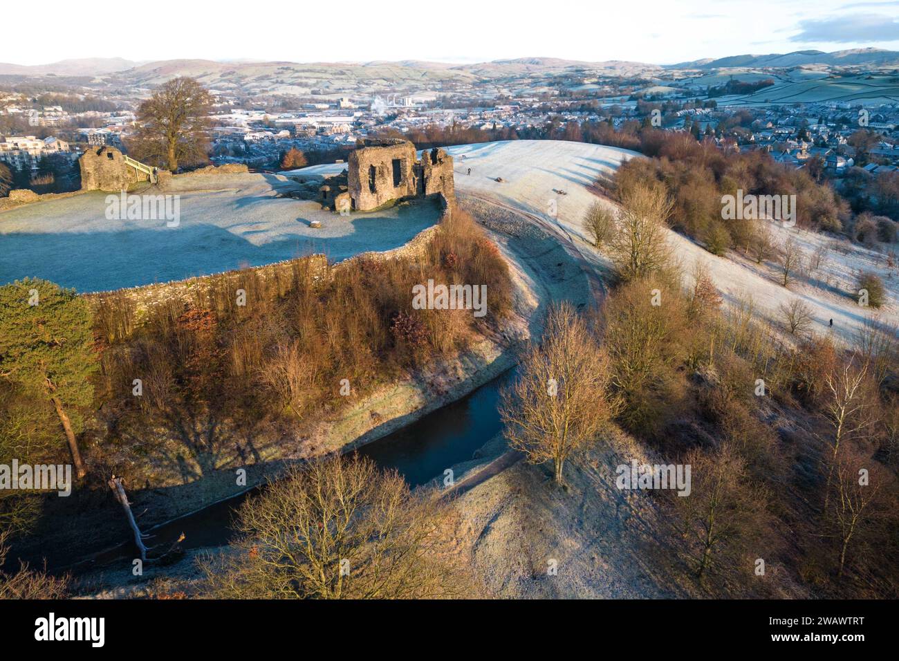 Kendal, Cumbria, 7 gennaio 2024 - Una notte di nebbia e temperature sotto lo zero ha portato una bella gelata mattutina alla città di Kendal in Cumbria domenica. Il castello di Kendal, che si affaccia sulla città medievale, era circondato da uno strato di ghiaccio bianco mentre gli escursionisti si godevano la vista. Le case ai piedi del castello sono sagomate in cerchi e gli ovali catturano anche il gelo. Credito: Stop Press Media/Alamy Live News Foto Stock