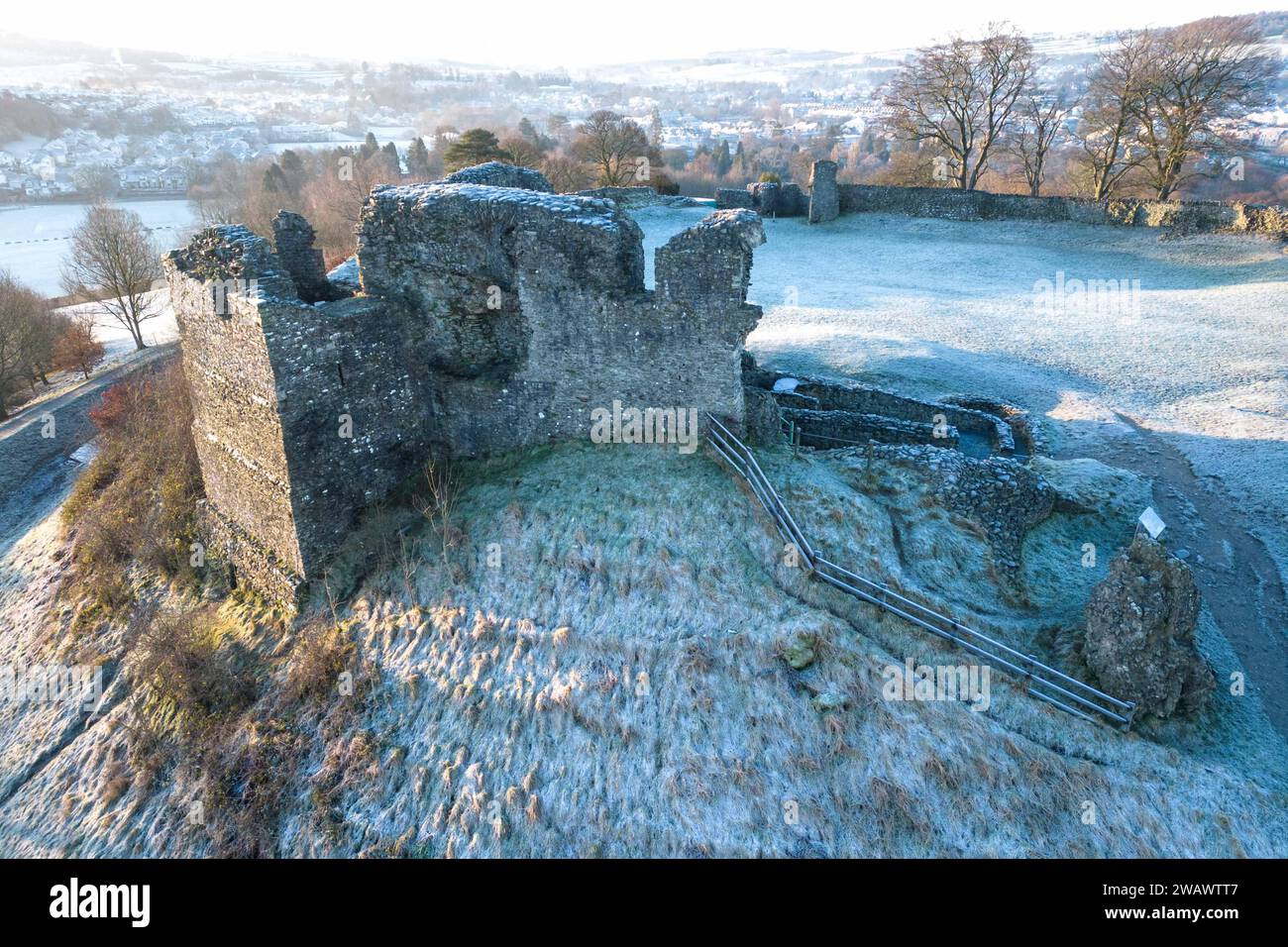 Kendal, Cumbria, 7 gennaio 2024 - Una notte di nebbia e temperature sotto lo zero ha portato una bella gelata mattutina alla città di Kendal in Cumbria domenica. Il castello di Kendal, che si affaccia sulla città medievale, era circondato da uno strato di ghiaccio bianco mentre gli escursionisti si godevano la vista. Le case ai piedi del castello sono sagomate in cerchi e gli ovali catturano anche il gelo. Credito: Stop Press Media/Alamy Live News Foto Stock