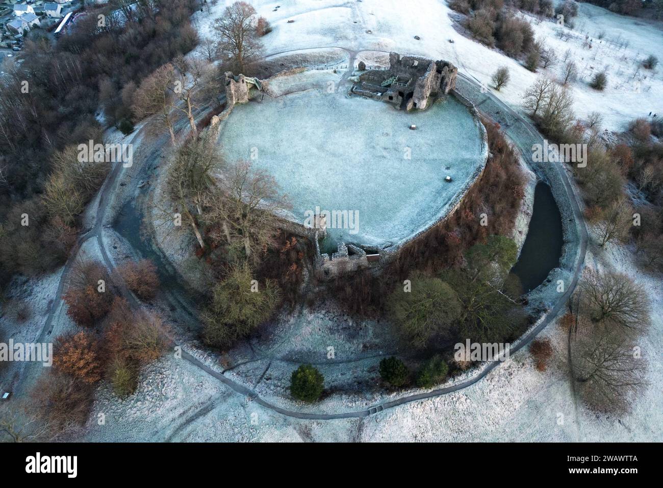 Kendal, Cumbria, 7 gennaio 2024 - Una notte di nebbia e temperature sotto lo zero ha portato una bella gelata mattutina alla città di Kendal in Cumbria domenica. Il castello di Kendal, che si affaccia sulla città medievale, era circondato da uno strato di ghiaccio bianco mentre gli escursionisti si godevano la vista. Le case ai piedi del castello sono sagomate in cerchi e gli ovali catturano anche il gelo. Credito: Stop Press Media/Alamy Live News Foto Stock