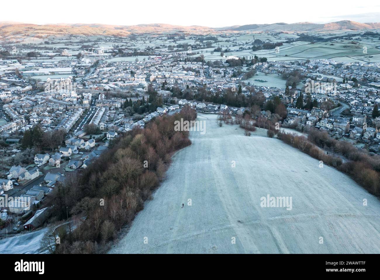 Kendal, Cumbria, 7 gennaio 2024 - Una notte di nebbia e temperature sotto lo zero ha portato una bella gelata mattutina alla città di Kendal in Cumbria domenica. Il castello di Kendal, che si affaccia sulla città medievale, era circondato da uno strato di ghiaccio bianco mentre gli escursionisti si godevano la vista. Le case ai piedi del castello sono sagomate in cerchi e gli ovali catturano anche il gelo. Credito: Stop Press Media/Alamy Live News Foto Stock