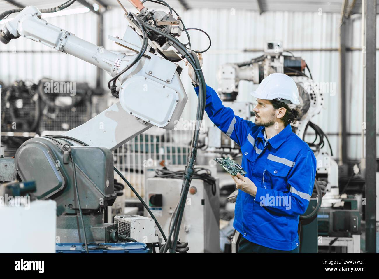 Il servizio di riparazione per tecnici sostituisce la parte rotta del braccio di saldatura robotizzato automatico industriale. il personale tecnico ripara la manutenzione della saldatrice robotizzata. Foto Stock