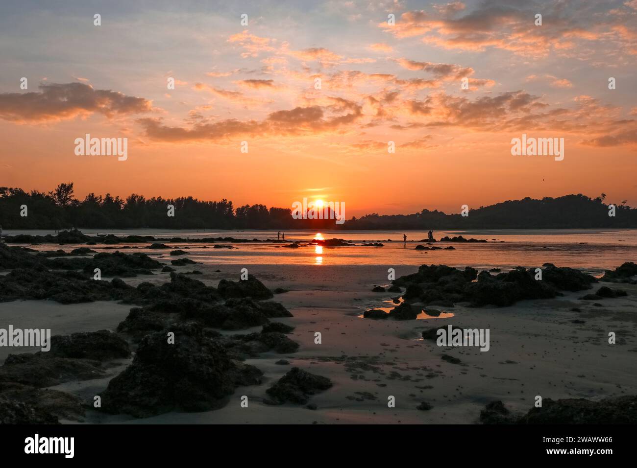 Magnifico tramonto colorato in una baia rocciosa. Foto Stock