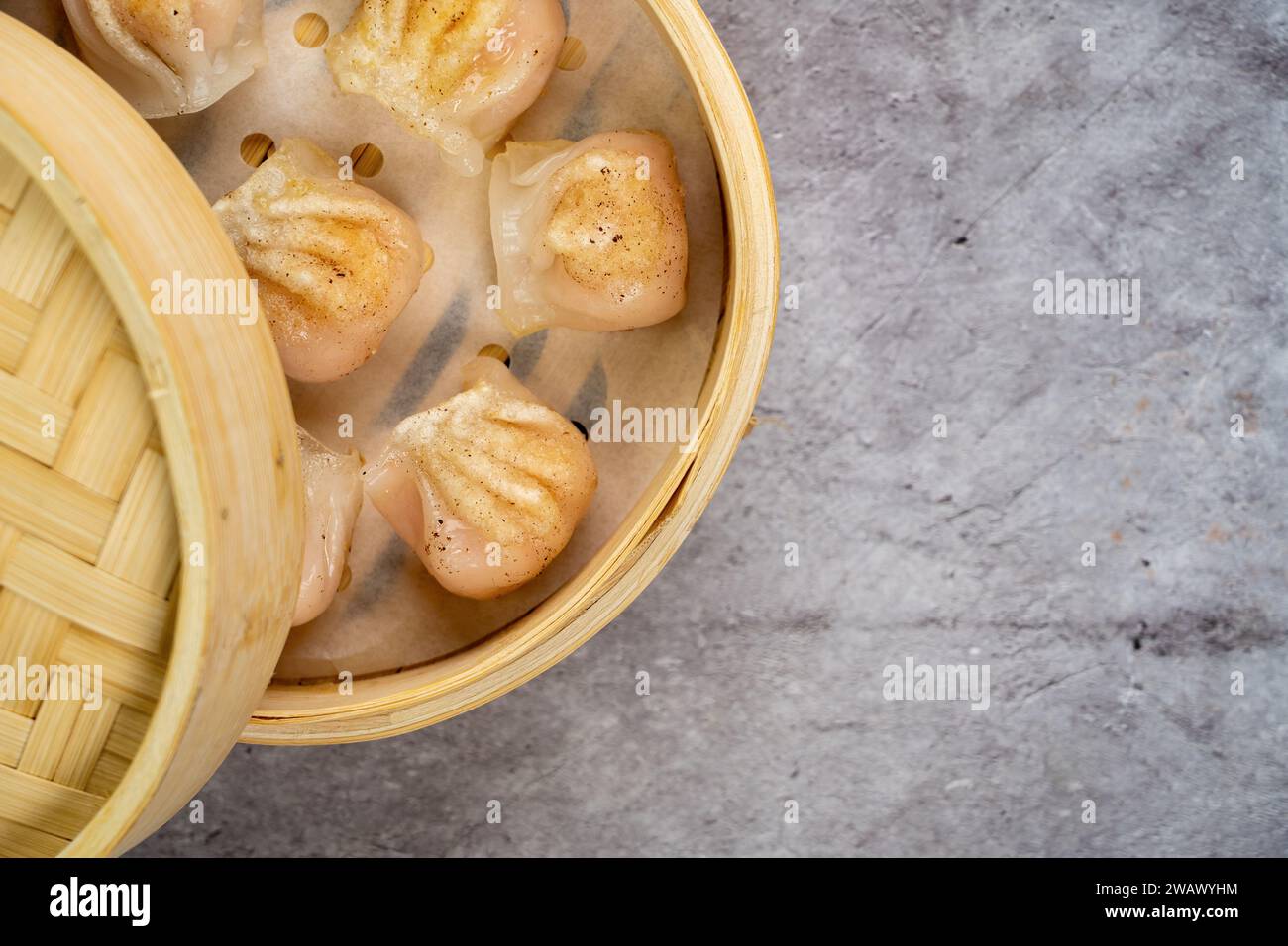 Gnocchi fatti in casa dim sum da vicino in una scatola di piroscafo di bambù sul tavolo. Vista superiore orizzontale dall'alto Foto Stock