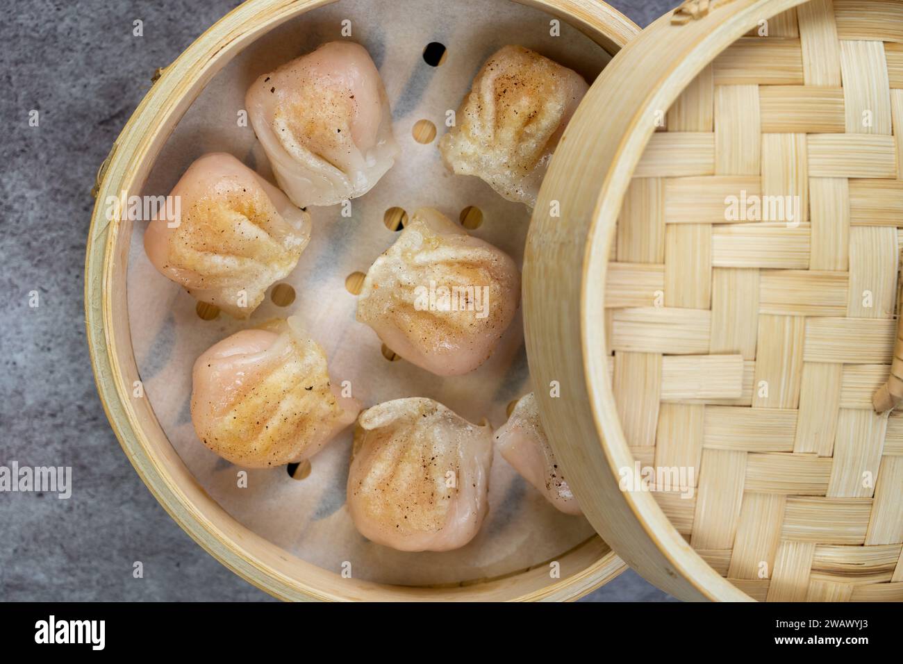 Gnocchi fatti in casa dim sum da vicino in una scatola di piroscafo di bambù sul tavolo. Vista superiore orizzontale dall'alto Foto Stock