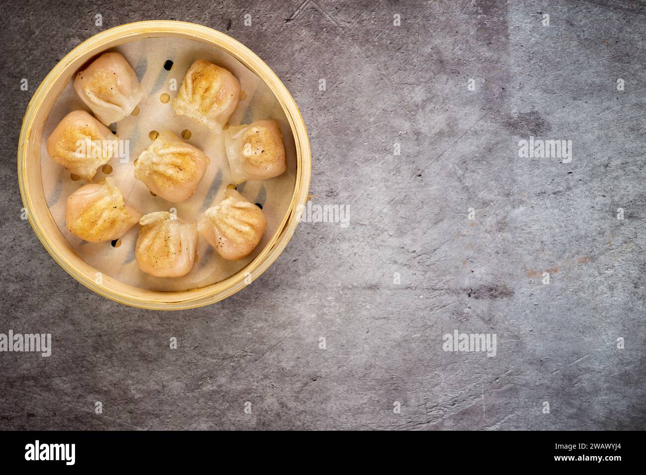 Gnocchi fatti in casa dim sum da vicino in una scatola di piroscafo di bambù sul tavolo. Vista superiore orizzontale dall'alto Foto Stock