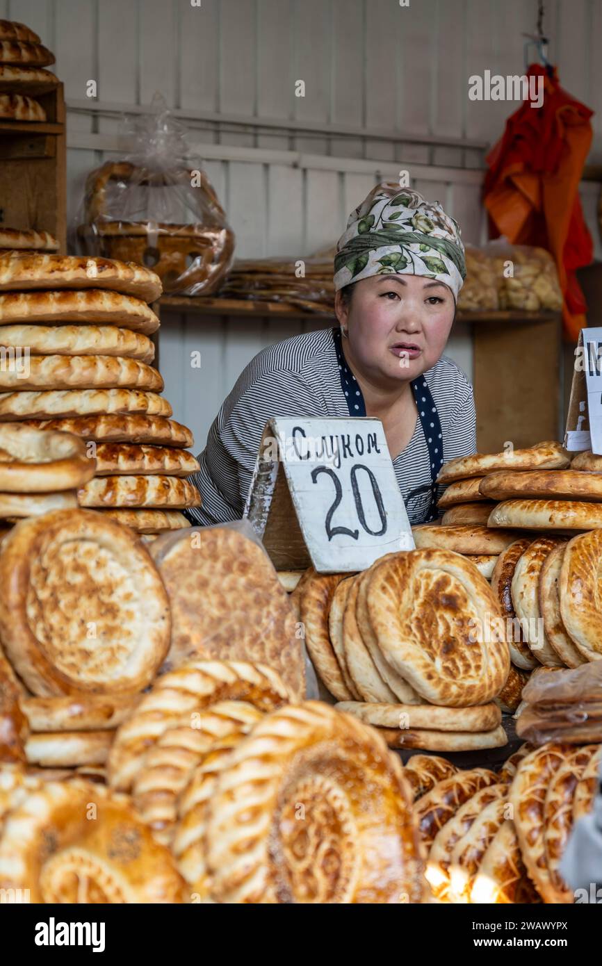 Donna che vende pane in una bancarella al mercato di Osh Bazaar, Bishkek, Kirghizistan Foto Stock