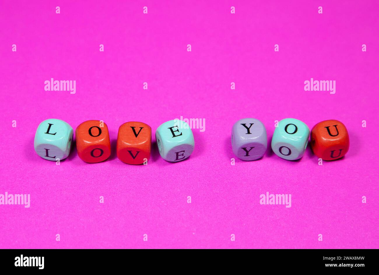 The Love You Written con perline cubiche di legno su sfondo rosa. Immagine decorativa, ornamentale. Foto Stock