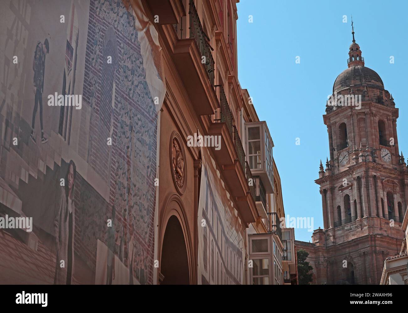 Il campanile nord in stile rinascimentale della cattedrale di Santa Iglesia Basílica de la Encarnación di Malaga e i murales lungo via St Augustin Malaga Spagna Foto Stock