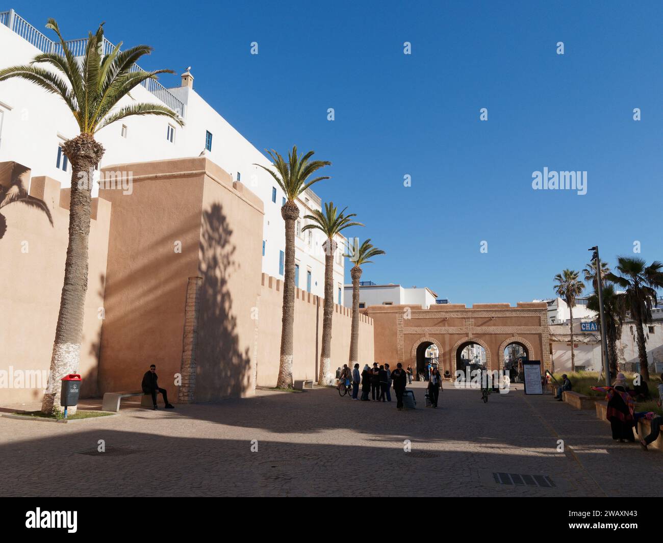 Persone nella strada principale della Medina con archi e fiancheggiate da palme nella città di Essaouira, in Marocco. 7 gennaio 2024 Foto Stock
