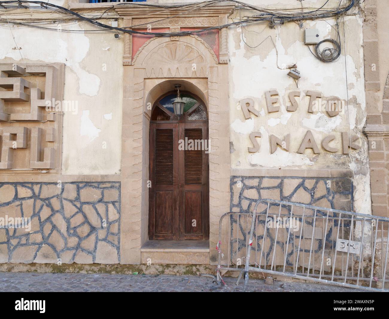 Ingresso del ristorante e cartello sul muro nella medina nella città di Essaouira, Marocco. 7 gennaio 2024 Foto Stock