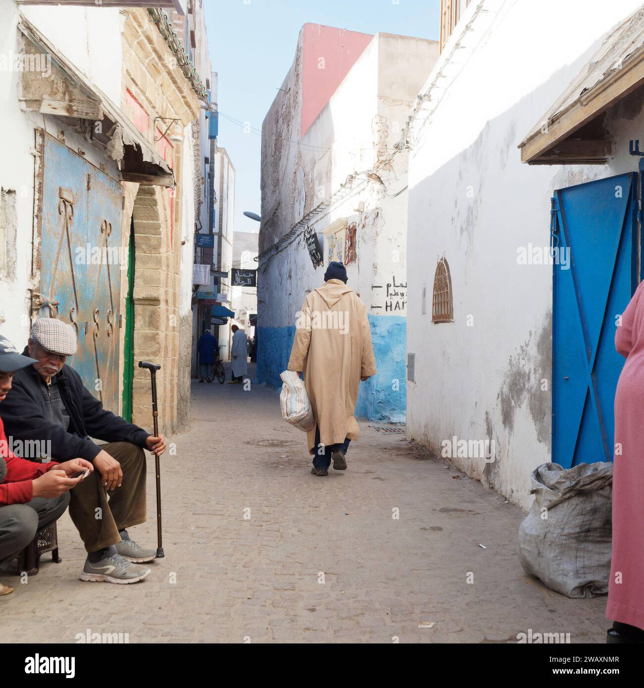 Gente del posto in una strada stretta e colorata nella storica medina della città di Essaouira, in Marocco. 7 gennaio 2024 Foto Stock