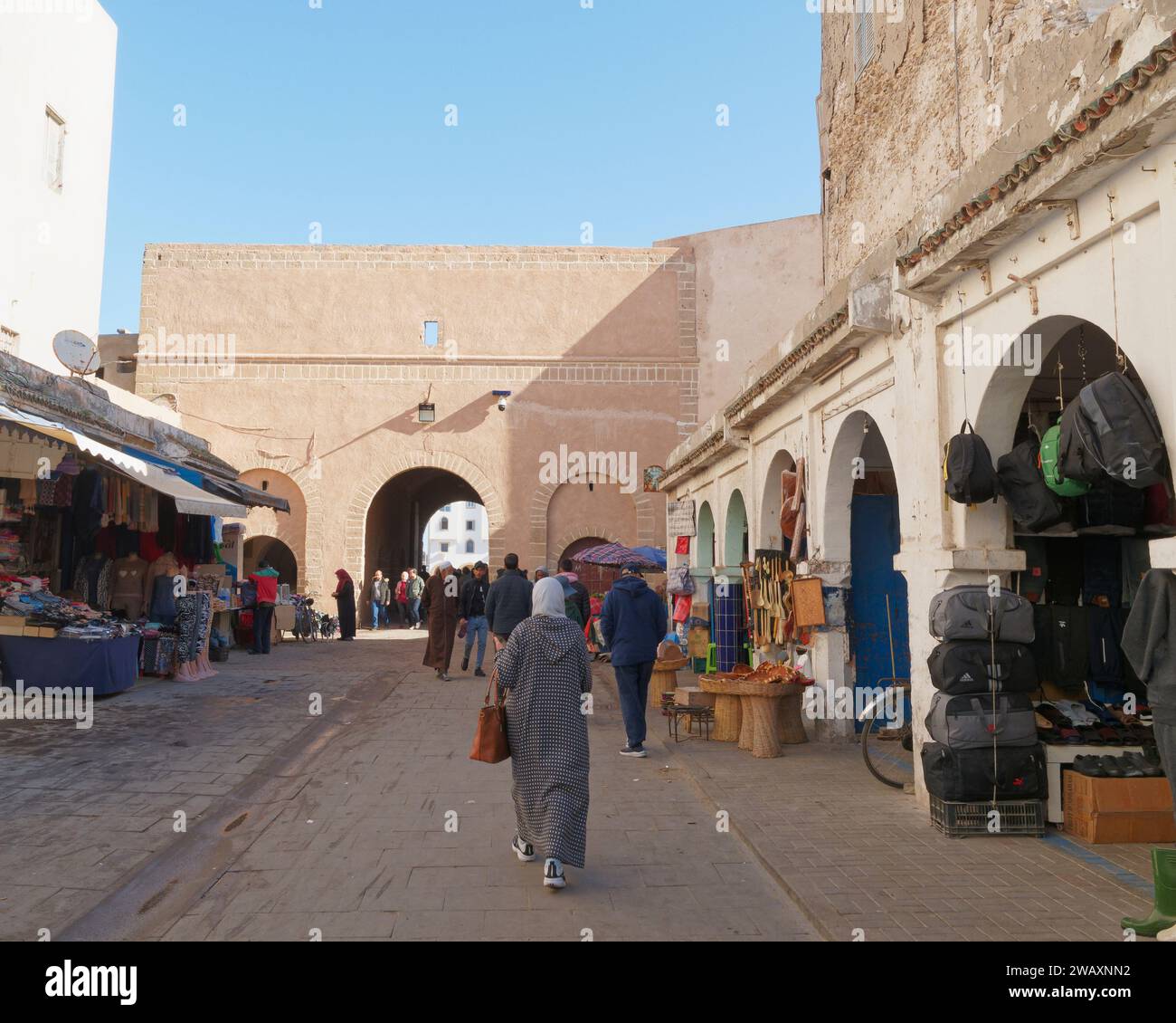 Le persone nella strada principale con il centro e negozi di abbigliamento nella storica medina nella città di Essaouira, in Marocco. 7 gennaio 2024 Foto Stock