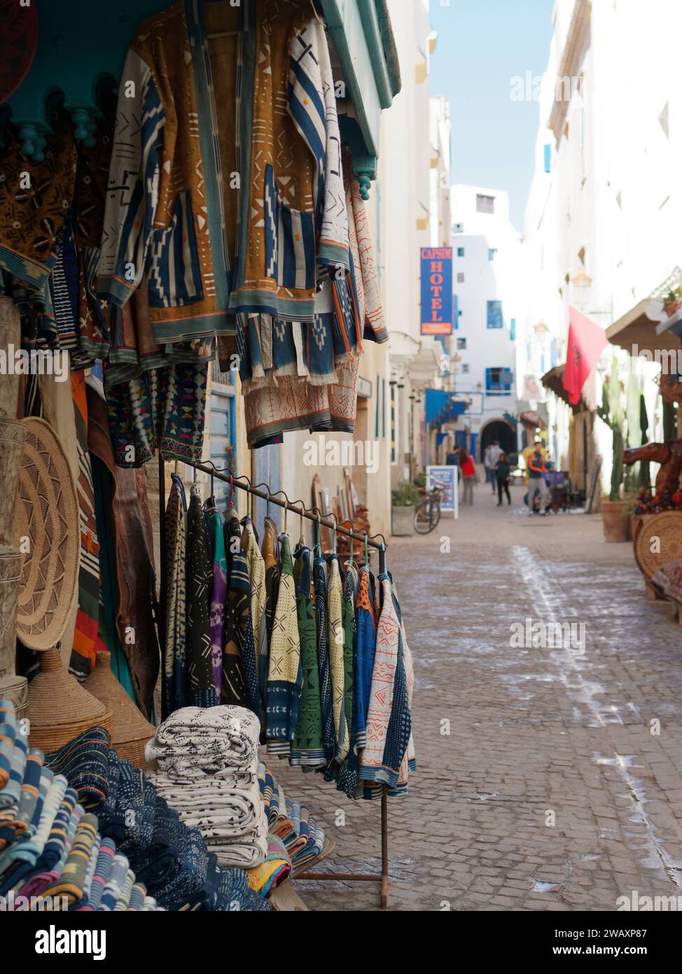 Strada stretta con negozi di abbigliamento nella storica medina della città di Essaouira, in Marocco. 7 gennaio 2024 Foto Stock
