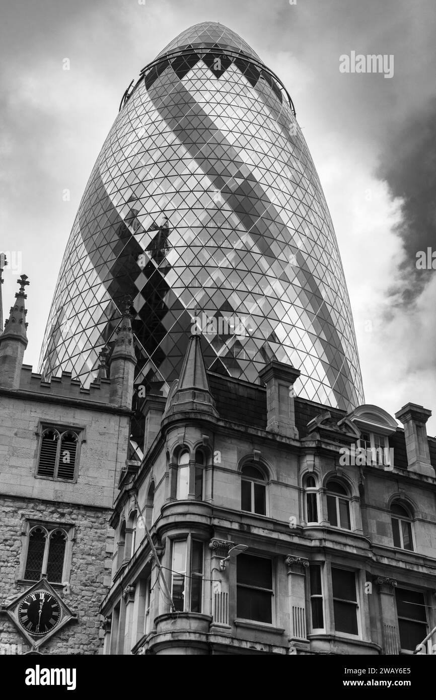 Il famoso edificio londinese Gherkin sullo sfondo, con alcuni edifici molto vecchi, è in primo piano Foto Stock