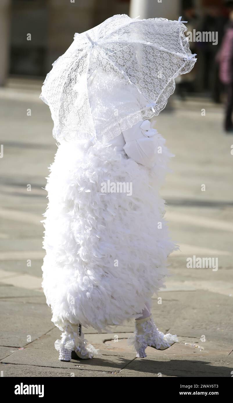 Donna in bianco vestita con ombrello leggero durante il carnevale a VENEZIA in Italia Foto Stock