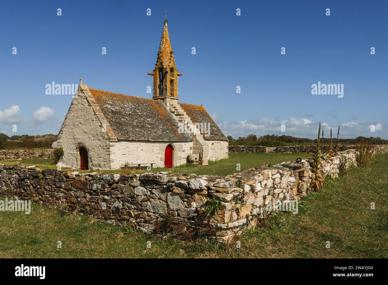 La bellissima cappella Saint-Vio e un muro a secco nella campagna del Pays Bigouden in Bretagna, Francia Foto Stock