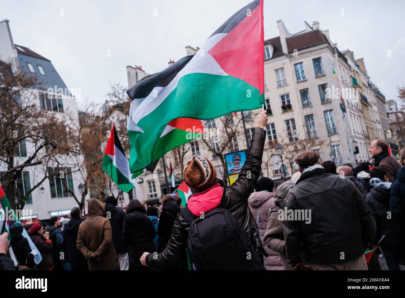 Parigi, Francia - 31 dicembre 2023: I cittadini alzano la bandiera palestinese contro la guerra israeliana. Foto Stock