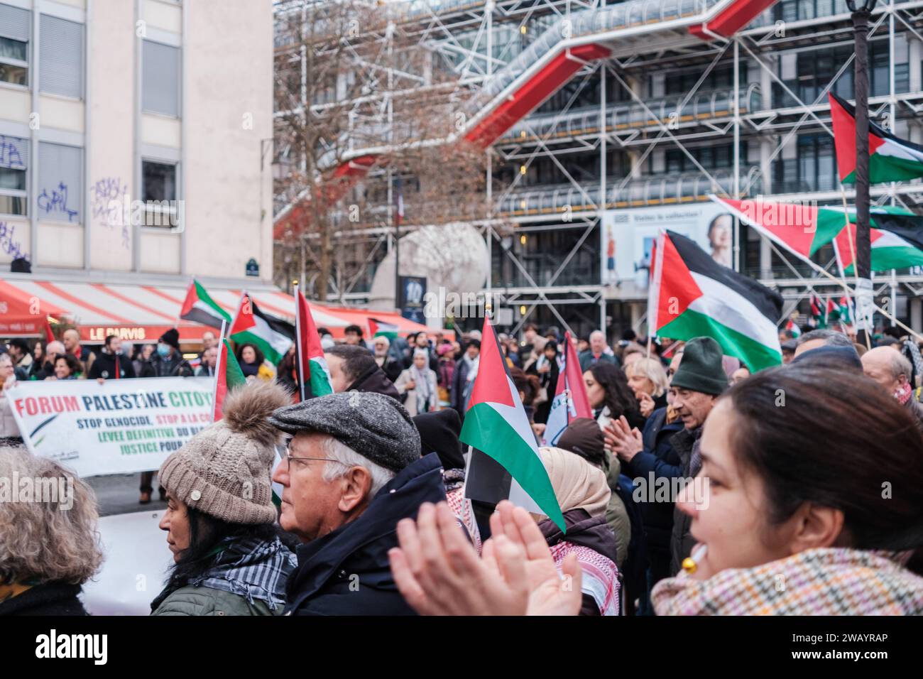 Parigi, Francia - 31 dicembre 2023: I cittadini alzano la bandiera palestinese contro la guerra israeliana. Foto Stock