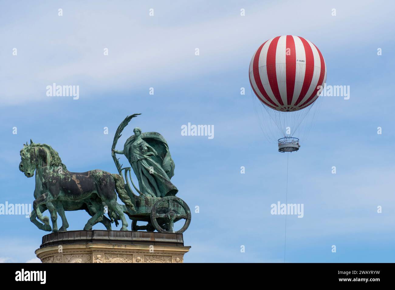 Una statua nella storica Piazza degli Eroi a Budapest, Ungheria - 2 agosto 2023. Sullo sfondo è presente un palloncino rosso e bianco Foto Stock