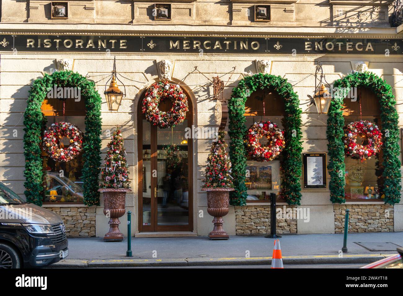 Davanti a un ristorante italiano con decorazioni natalizie a Budapest il 18 dicembre 2023. Foto Stock