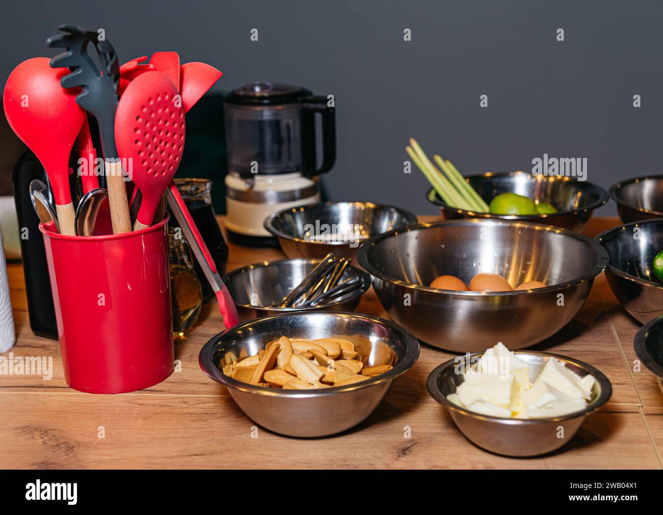 Ciotole di ingredienti e utensili sul tavolo da cucina. Master class culinario. Foto Stock