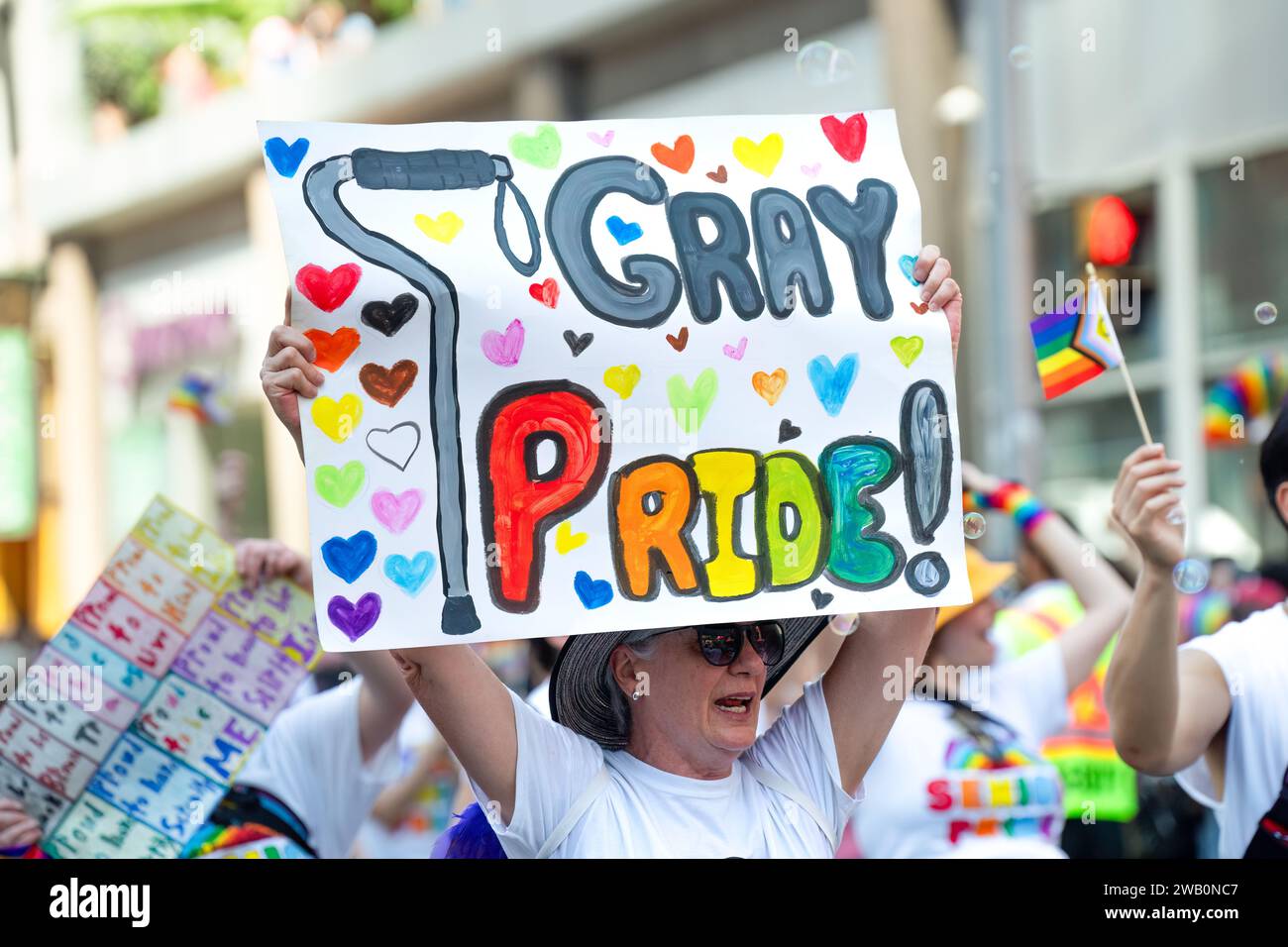 Un senior ha un "Gray Pride!" Cartello mentre marciate per la Toronto Pride Parade. Foto Stock