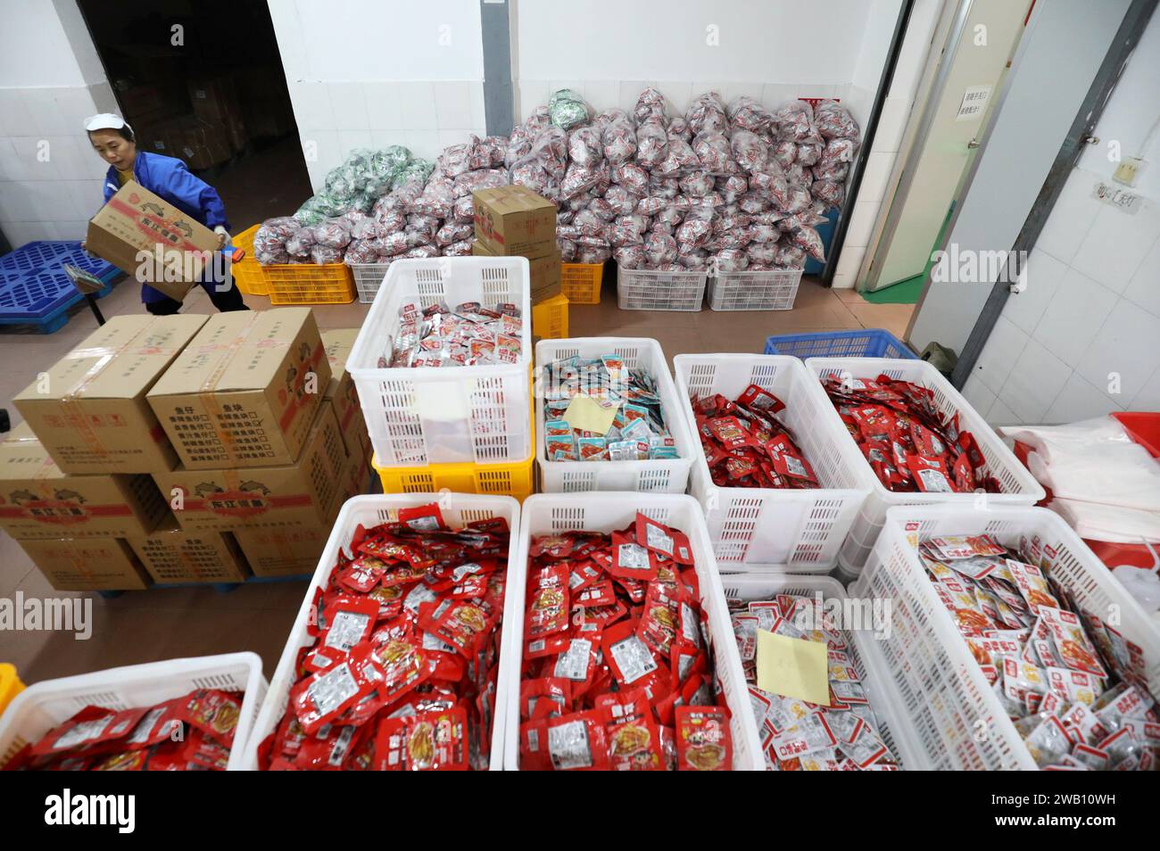 ZIXING, CINA - 4 GENNAIO 2024 - i lavoratori producono prodotti ittici in un laboratorio di un'azienda alimentare naturale nella città di Zixing, provincia di Hunan, Cina, gennaio Foto Stock
