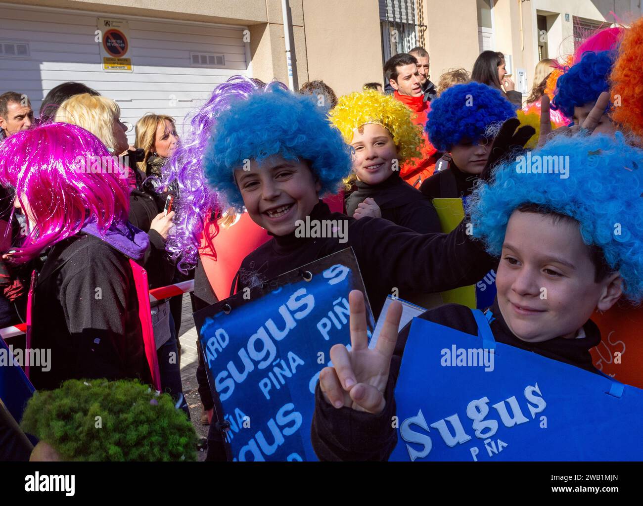 Barcellona, Spagna - 28 febbraio 2015: Allietati scolari in parrucche colorate a una sfilata di carnevale, che mostra un'unità di costumi a tema caramelle e cheerfu Foto Stock