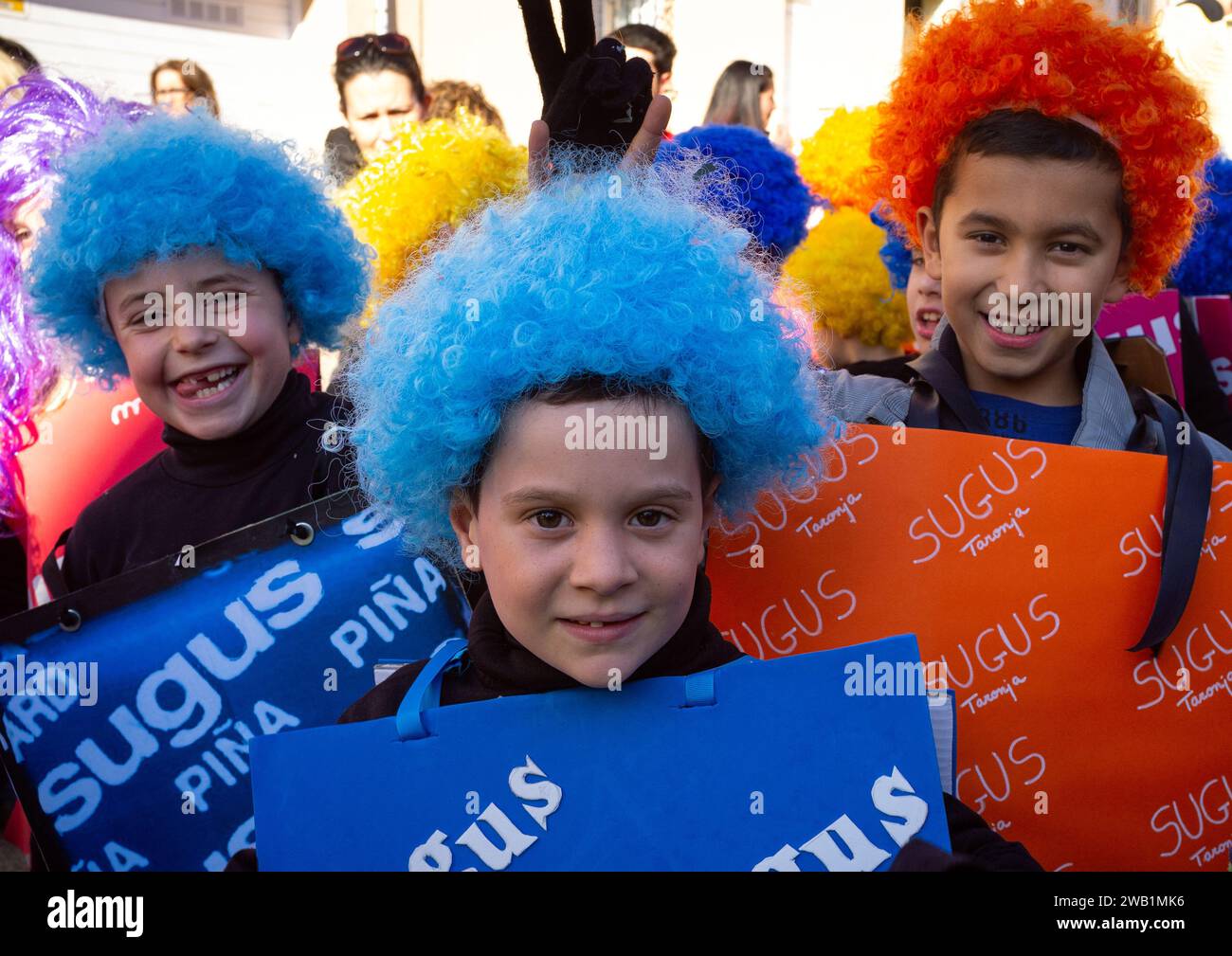 Barcellona, Spagna - 28 febbraio 2015: Allietati scolari in parrucche colorate a una sfilata di carnevale, che mostra un'unità di costumi a tema caramelle e cheerfu Foto Stock