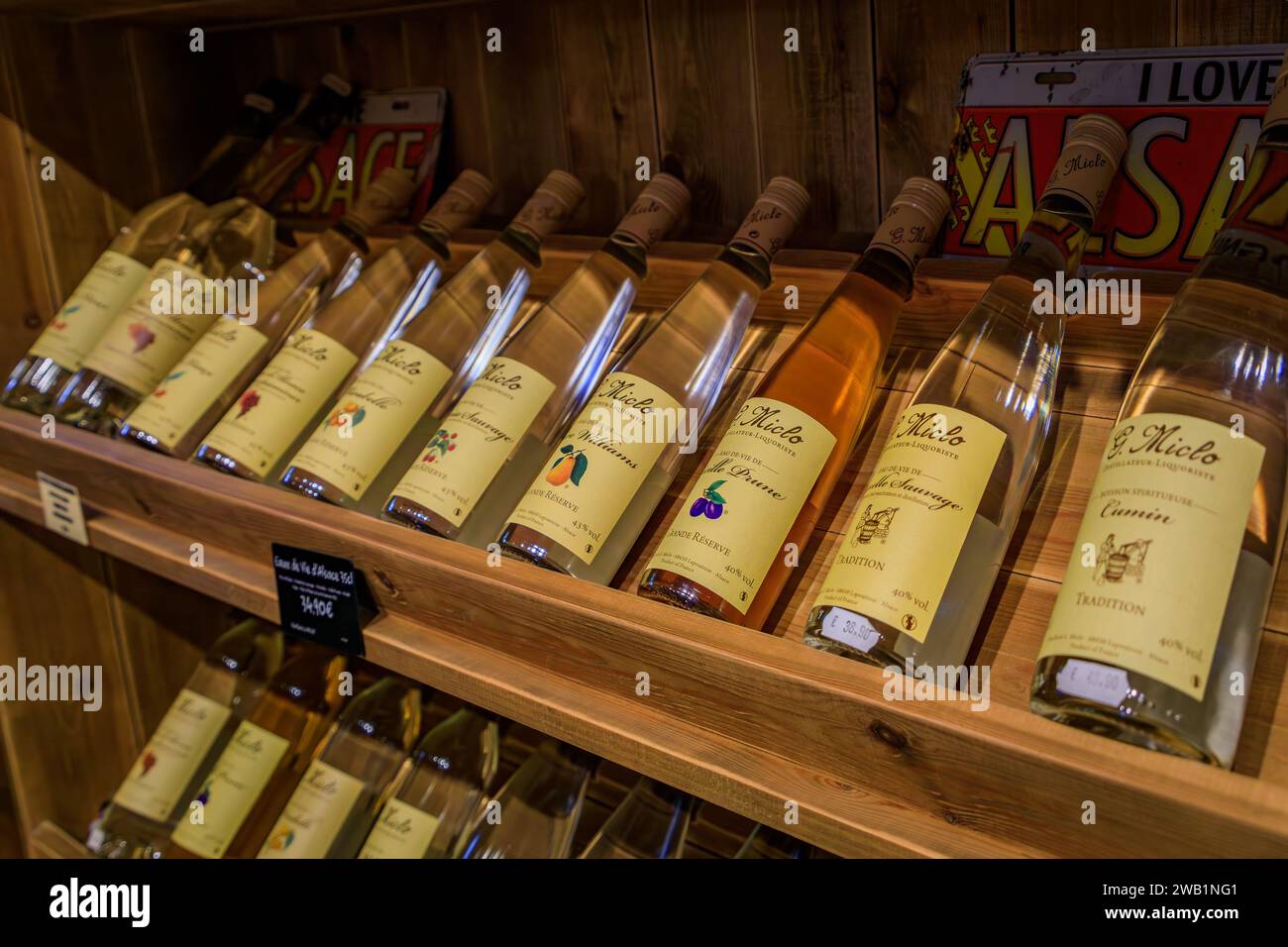 Colmar, Francia - 4 giugno 2023: Tradizionale eau de vie artigianale brandy di frutta della distilleria artigianale G Miclo in mostra in un negozio Foto Stock