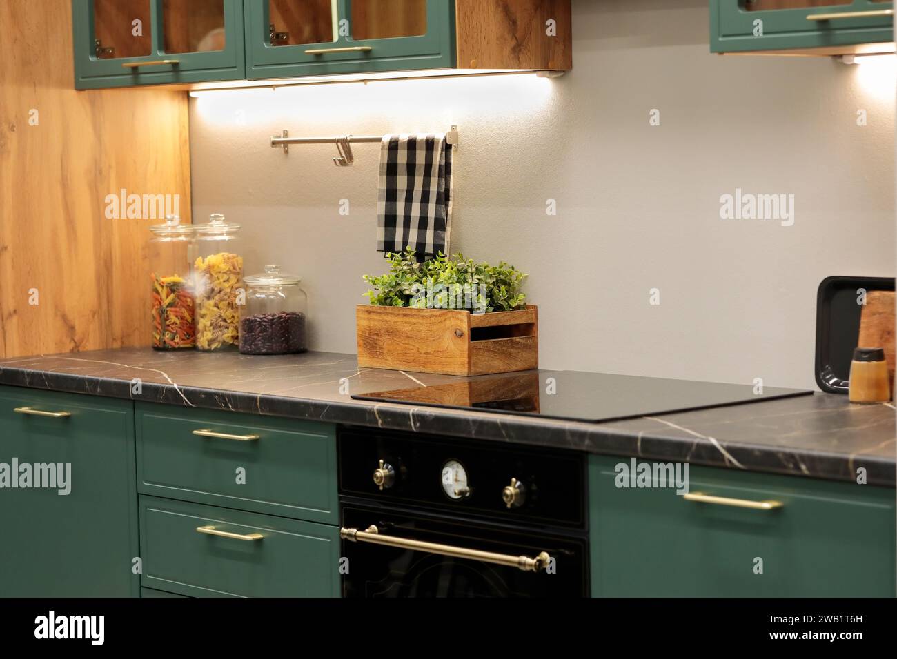 Moderno interno della cucina con ripiano in laminato ad alta pressione e piano cottura a induzione. Messa a fuoco selettiva. Foto Stock