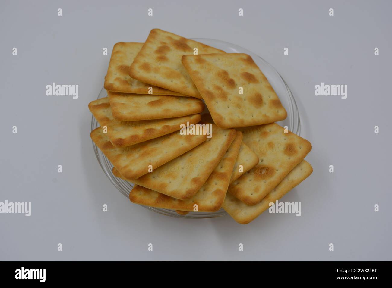 Biscotti di marca, fatti in fabbrica, grossi cracker salati sono disposti su uno sfondo bianco. Foto Stock