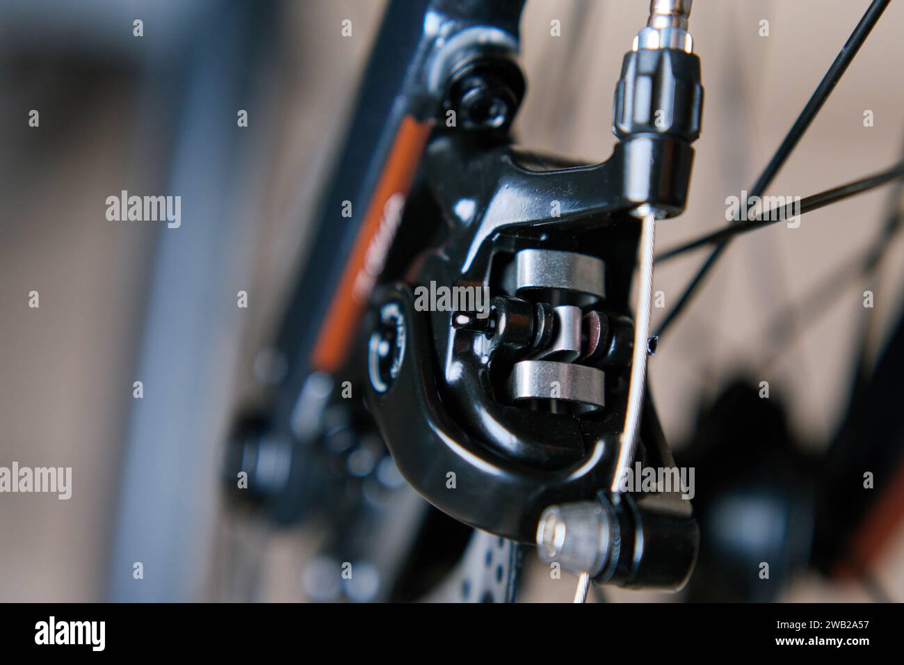 Parte dell'impianto frenante della bicicletta. Disco freno e pastiglie dei freni in metallo grigio sulla bici da strada, primo piano. Foto Stock