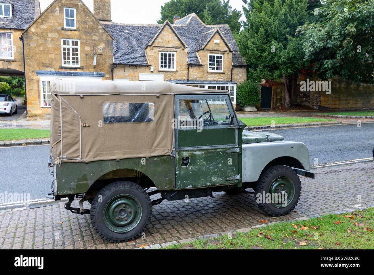 Veicolo Land Rover serie 1 classico parcheggiato nel villaggio di Broadway, Cotswolds, Inghilterra, l'auto ha sostituito i parafanghi anteriori e la tela marrone, Inghilterra, Regno Unito Foto Stock