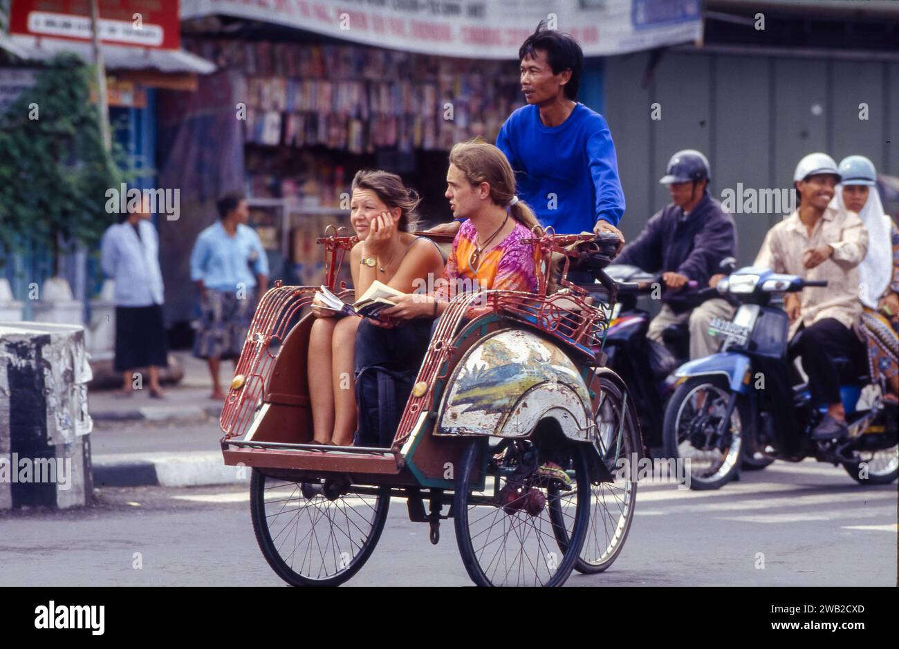 Indonesia, Yogyakarta. I turisti in risciò durante un tour della città. Foto Stock