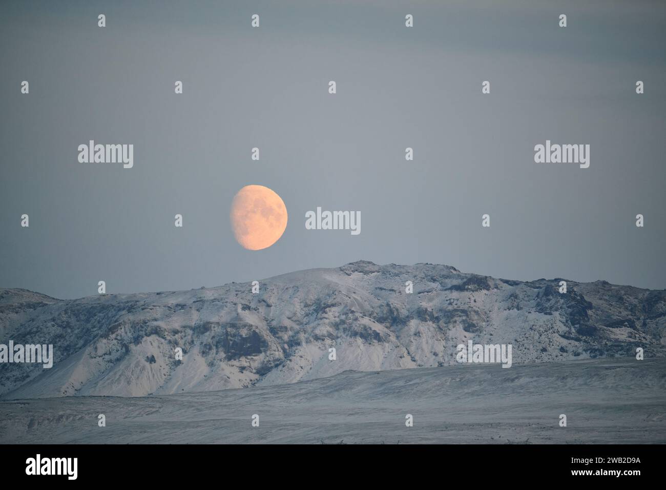 Luna che brilla sulle montagne innevate in inverno Foto Stock