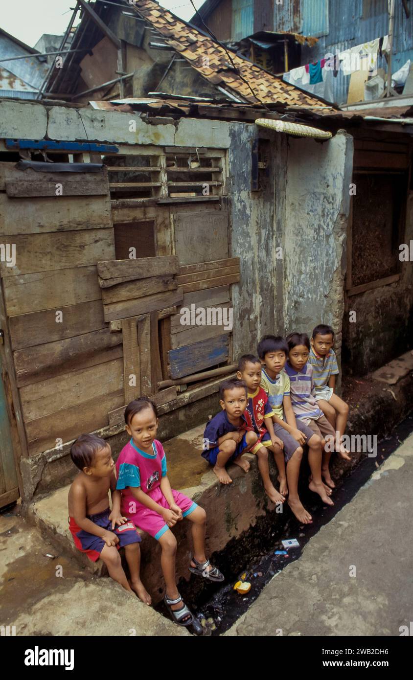 Indonesia, i bambini di Giava siedono sopra una fogna aperta in una baraccopoli Foto Stock