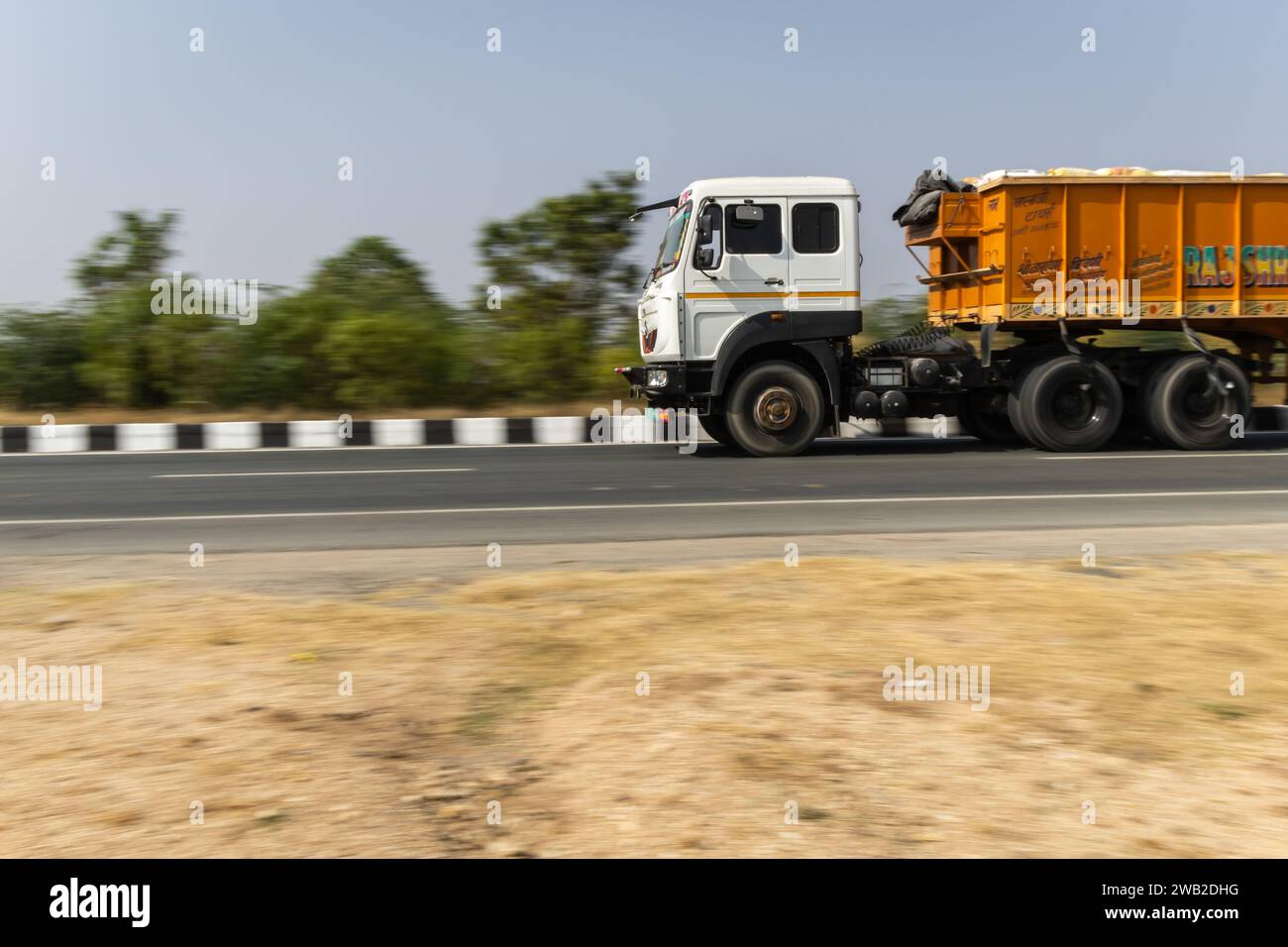 Il camion che passa sull'autostrada nazionale con sfondo sfocato di giorno da un'immagine ad angolo piatto viene scattato all'autostrada nazionale jodhpur udaipur rajasthan india ON Foto Stock